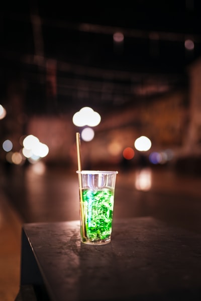 清楚饮用玻璃杯与绿色的液体在棕色木桌上
